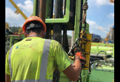 A worker operating a drill rig