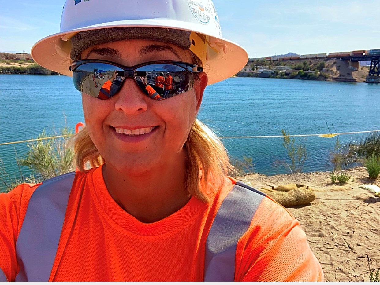 Pictured: Patty Anaya, Project Manager at Cascade Environmental, wearing a hard hat and sunglasses on a project site