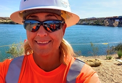 Pictured: Patty Anaya, Project Manager at Cascade Environmental, wearing a hard hat and sunglasses on a project site