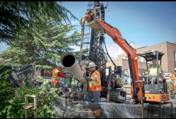 a worker moving a pipe