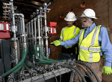 A photo of site workers inspecting an injection system